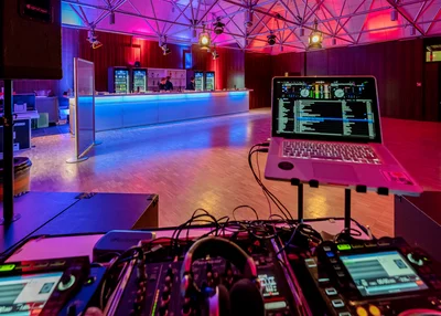 Bild vom DJ-Pult und Bar im KU'KO Saal Chiemgau. 