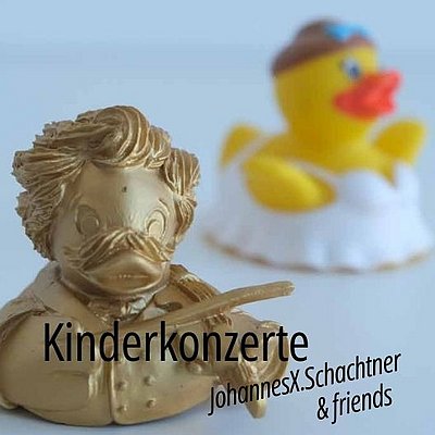 goldene Badeente mit Geige und Frisur aus der Zeit Johann Strauß als Symbol für Kinderkonzert